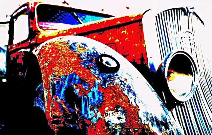 Old, rusty Lastwagen mit bunten, verwitterten Details und einer auffälligen Motorhaube.